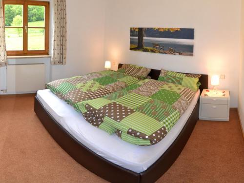 施利尔塞Haus Sonnbichl的一间卧室配有一张带绿色棉被的大床