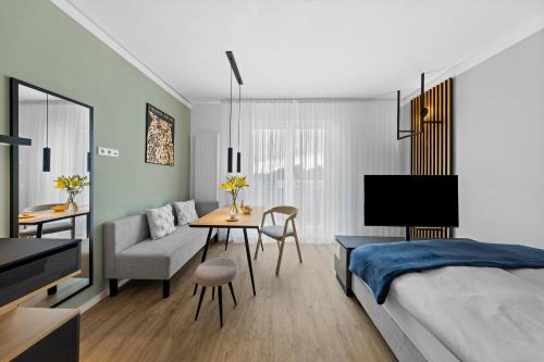 柏林Nena Apartments Berlin - Adlershof - "New Opening 2024"的一间卧室配有一张床、一张桌子和一张沙发