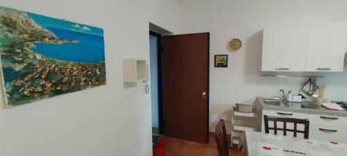 蒙德罗Mondello Blue Sea的厨房配有桌子、水槽和墙上的绘画作品
