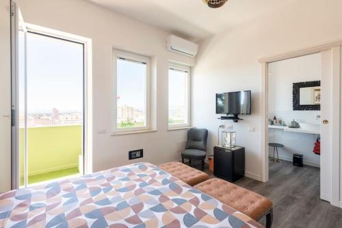 卡利亚里Eleventh Floor Suites的一间卧室设有一张床、一台电视和窗户。