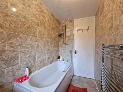 拉格比Nice Living Serviced Accommodations 7的设有带浴缸和淋浴的浴室。