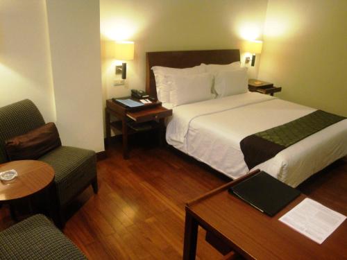 美娜多美娜多品质酒店的酒店客房带一张床、一张桌子和椅子