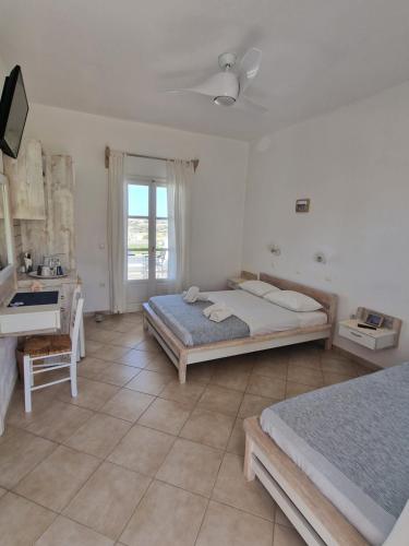 斯希努萨岛Harama hotel Schinoussa的一间卧室配有两张床和一张书桌