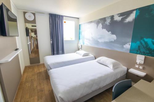 瓦朗斯堡Kyriad Direct - Bourg les Valence的酒店客房设有两张床和一张桌子。