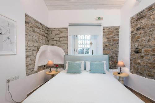 KavallérainaNausica House的卧室配有白色的床和两盏灯。