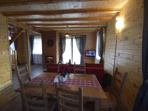 OsiekWooden Holiday Home in Skrzynia with Terrace的一间带木桌和椅子的用餐室