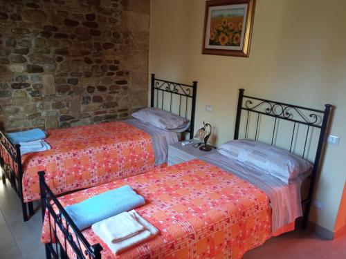 MiglionicoVilla Becci的一间卧室设有两张床和石墙