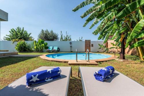 马拉特克西Villa Almez in Marratxí的院子里一个带两把蓝色椅子的游泳池