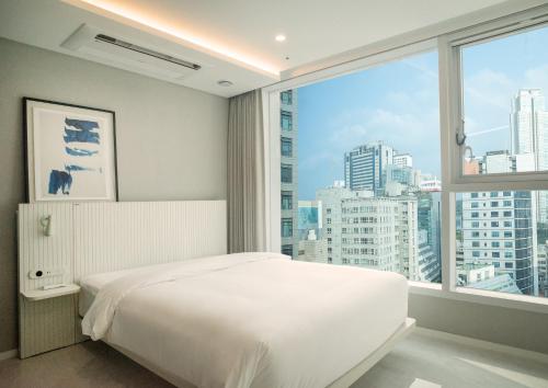首尔UH FLAT The Seocho的卧室设有白色的床和大窗户