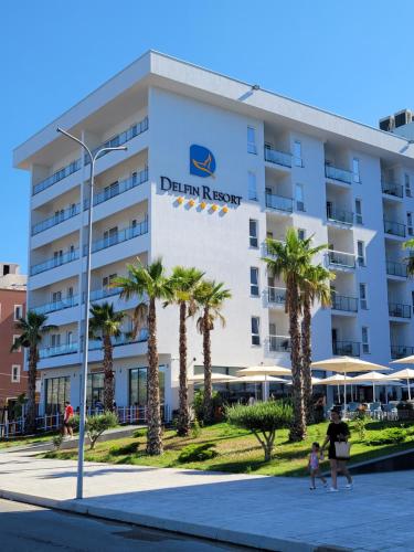 圣金Delfin Resort Kune的前面有棕榈树的酒店