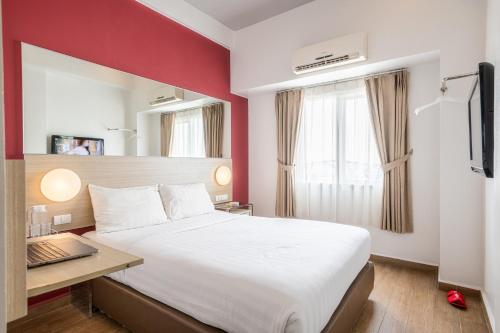 雅加达Monoloog Hotel Pasar Baru的酒店客房设有一张大床和一张书桌。