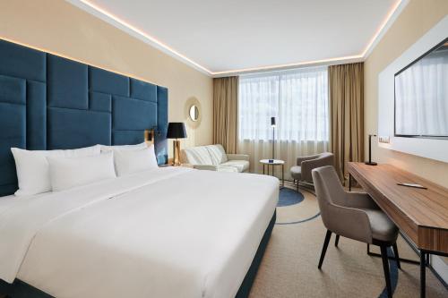 什切青丽笙布鲁什切青酒店的酒店客房设有一张大床和一张书桌。