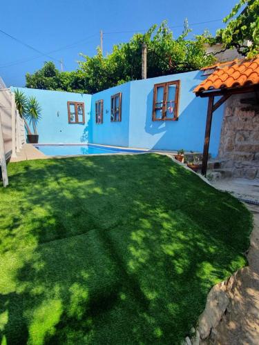 拜昂Casa da Poça的一个带绿色草坪的蓝色房子的庭院
