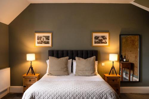 温彻斯特普拉夫伊坎阿巴斯宾馆的一间卧室配有一张大床和两盏灯。