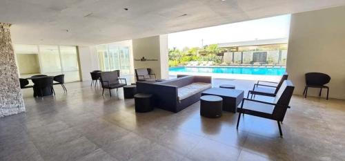 巴科洛德Mesavirre Garden Residence的带沙发和椅子的客厅以及游泳池。