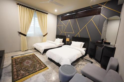 伊斯兰堡SK Residence的一间带两张床和一张沙发的卧室