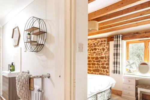 PentneyThe Gig House - relaxing countryside spa break的以及1间带白色墙壁和木质天花板的浴室。