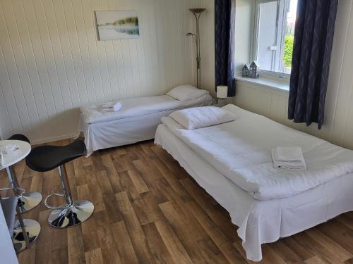 希尔科内斯SAGA Overnatting的客房设有两张床、一把椅子和窗户。