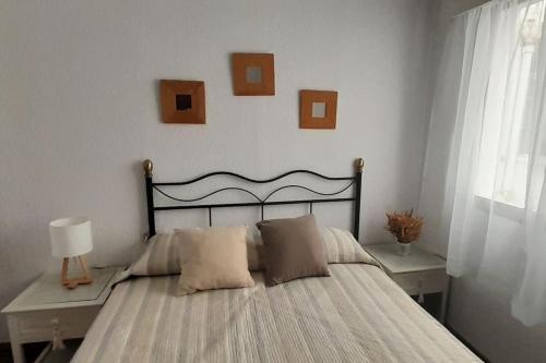 韦尔瓦Apartamento Huelva Centro的卧室配有一张墙上挂有照片的床