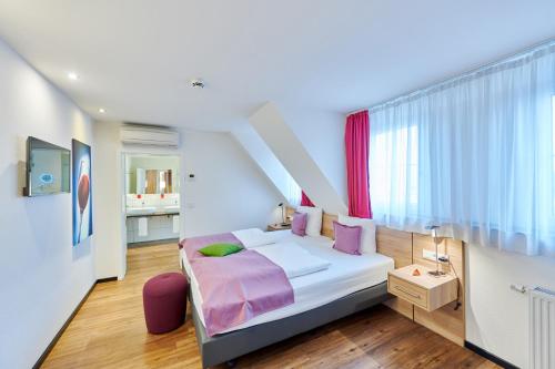 Nieder-Olm达斯克拉斯旅馆的一间卧室配有一张带紫色枕头的床