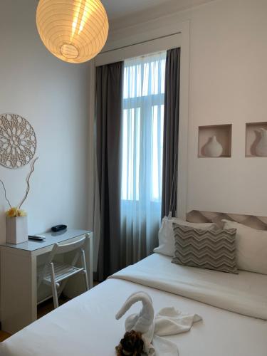 马托西纽什盆索中央旅馆的一间卧室配有一张床和一张桌子,上面有天鹅