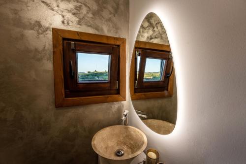 SaschizFlori Haus Saschiz的浴室设有水槽和墙上的两面镜子