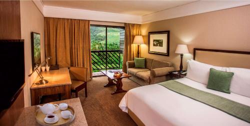 温特顿Drakensberg Sun Resort的配有一张床和一张书桌的酒店客房