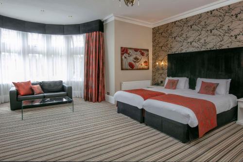 福克斯通贝斯特韦斯特Plus伯灵顿酒店的酒店客房设有一张大床和一张沙发。