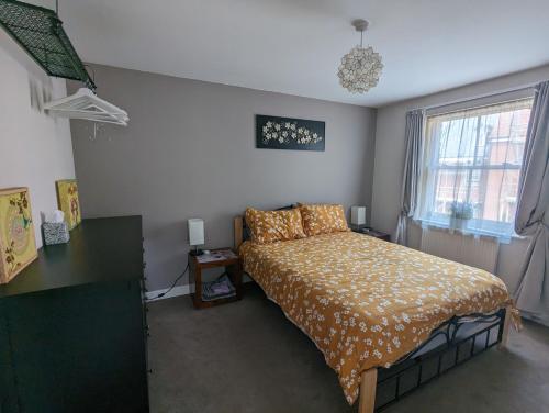 格拉斯顿伯里Namastay-Central Glastonbury的一间卧室配有一张床、一张书桌和一个窗户。