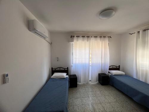 伯利恒Naji's House in Bethlehem-Full apartement的客房设有两张床和窗户。