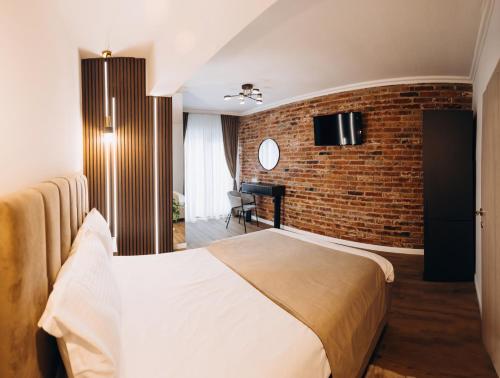 克卢日-纳波卡Pensiunea Brici Junior的酒店客房,设有床铺和砖墙