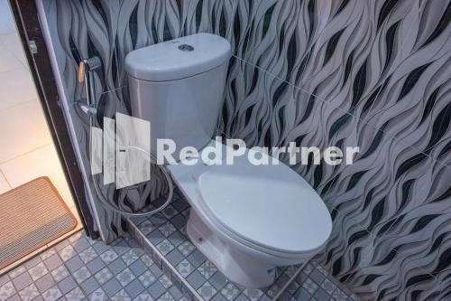 PalopoHotel Rai's Palopo Exclusive Mitra RedDoorz的浴室设有白色卫生间和墙壁