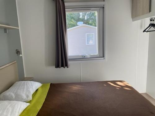 纳博讷普拉日Mobil-home (Clim, Tv)- Camping Narbonne-Plage 4* - 022的一间卧室设有一张床和一个窗口