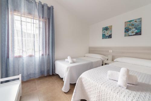 下布雷尼亚Estupendo adosado junto al mar, parking, terraza - Los Cancajos的白色的客房设有两张床和窗户。