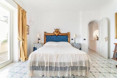 普莱伊亚诺Amalfi coast-Praiano Villa Cristina no steps的一间卧室配有一张大床和蓝色床头板