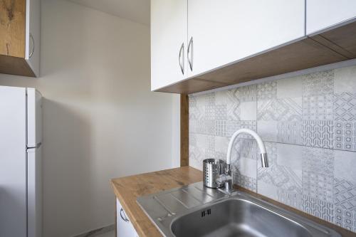 索波特01 Sopot - Apartament mieszkanie dla 6 osób的厨房配有水槽和冰箱