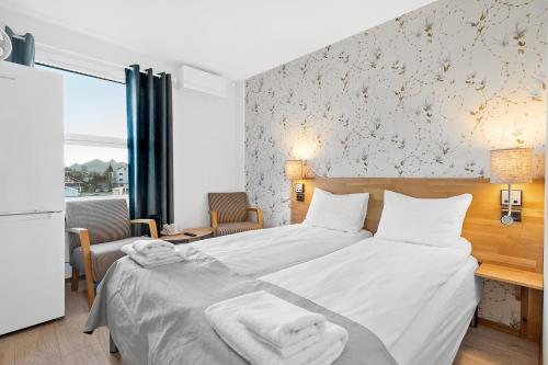 斯沃尔韦尔Marina Hotel Lofoten的一间卧室配有带毛巾的床