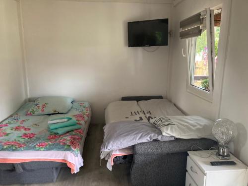 斯莫尔德兹诺Domek u Franka的一间卧室设有两张床,墙上配有电视。
