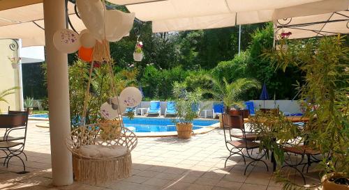 洛泽内茨Hotel Feniks的一个带椅子和植物的庭院和一个游泳池