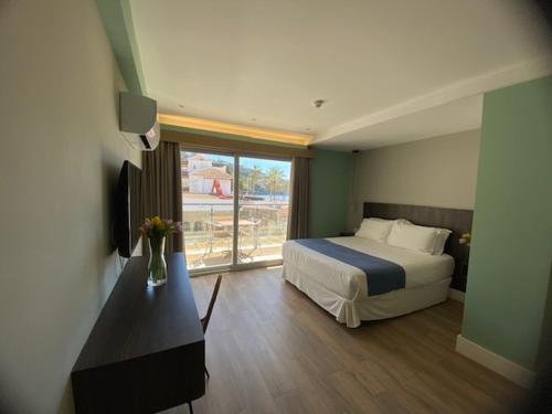 拉海瑞德拉H Boutique la Caleta bay的酒店客房设有床和窗户。