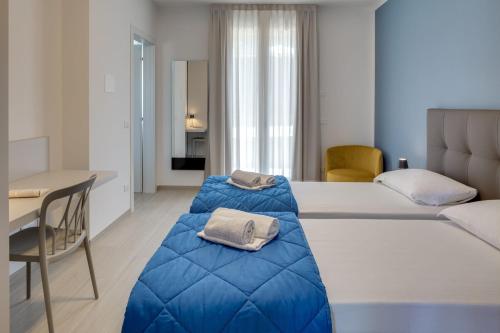 巴多利诺Oleandro Holiday Apartments的酒店客房配有两张床和一张书桌