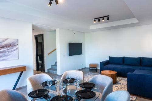塔哈佐特Luna Taghazout - Duplex Luxe - 4 Px的一间带桌椅和蓝色沙发的用餐室