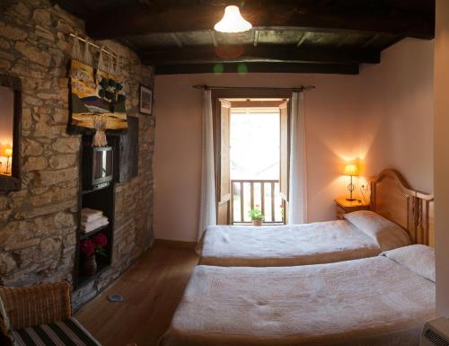 贝加德瓦尔卡尔塞Casa Rural Pandelo的一间卧室设有一张大床和石墙
