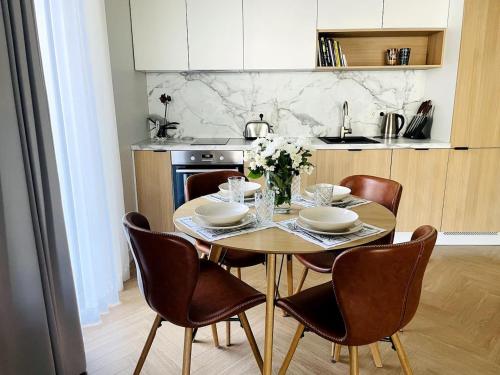 塔林Luxury Designer Suite的一间带木桌和椅子的厨房以及一间用餐室