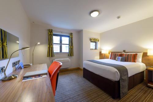 克兰菲尔德克兰菲尔德管理发展中心酒店的配有一张床和一张书桌的酒店客房