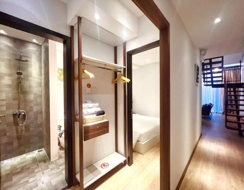 巴淡岛中心Oxy suites 2-02 at Shop House Meisterstadt Pollux Habibie的带淋浴的浴室以及通往卧室的门