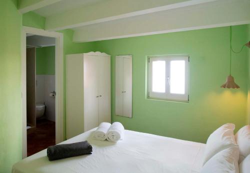 休达德亚RifugioAzul & RifugioAzul Boutique的绿色卧室,配有带毛巾的床