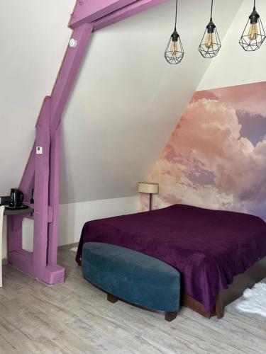 达克斯Le Montmieri的一间卧室配有一张紫色的床和一幅画