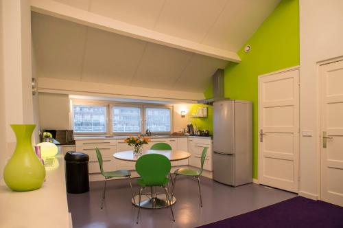 马斯特里赫特PetitGrandeur的厨房配有桌椅和冰箱。