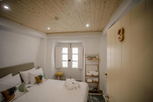 奥比多斯Óbidos Pátio House的卧室配有白色的床和窗户。